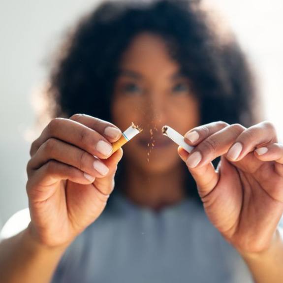 a woman breaking a cigarette in half