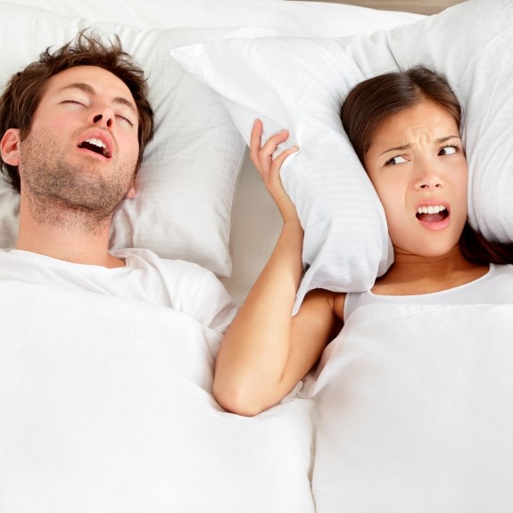 Frustrated woman in bed with snoring man