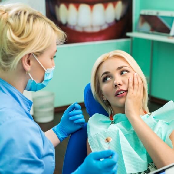 Woman discussing the cost of dental emergencies with dentist