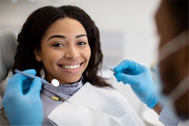 a patient smiling while getting a dental checkup