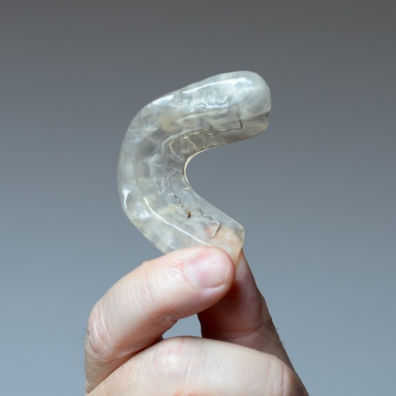 Person holding a custom nightguard for bruxism