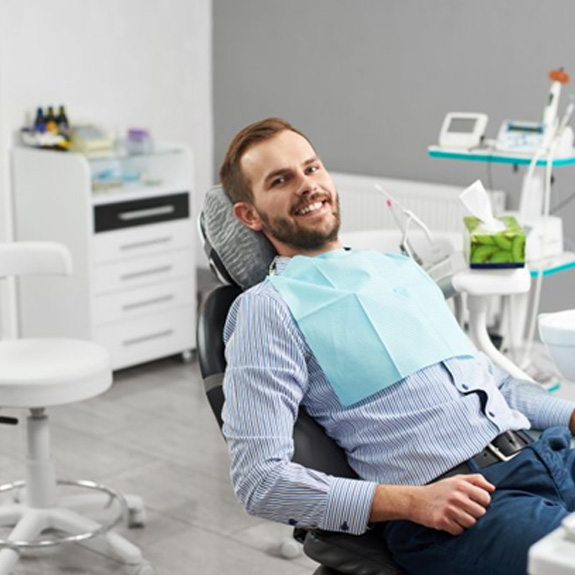 a dental patient smiling while visiting his dentist