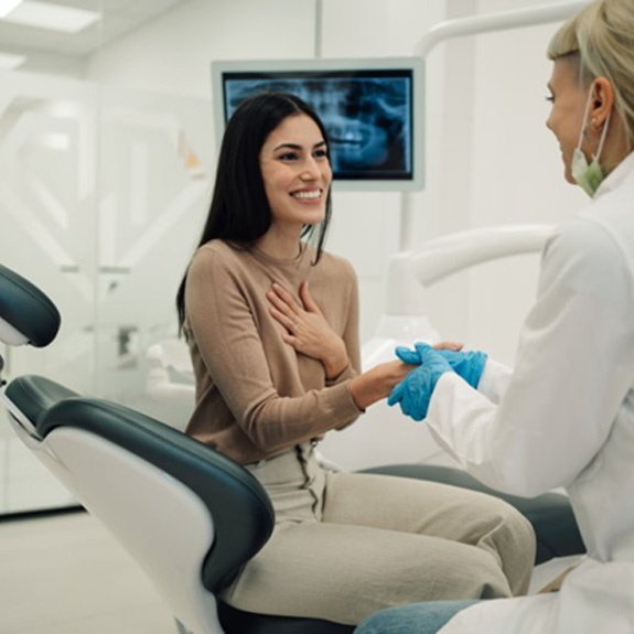 a nervous patient smiling at her dentist