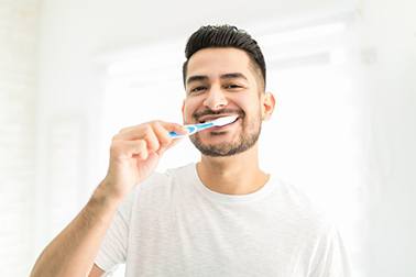 a man brushing his teeth in the morning
