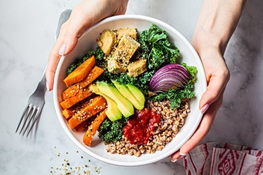 a person holding a bowl of healthy food