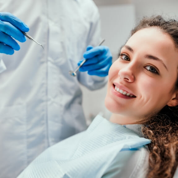 Woman smiling during preventive dentistry checkup and teeth cleaning visit