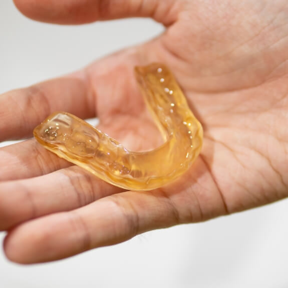 Person holding a custom nightguard for bruxism