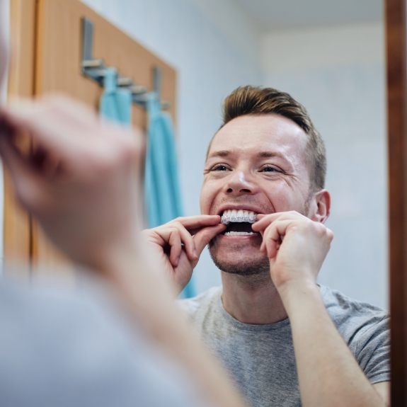 Man using at home teeth whitening kit