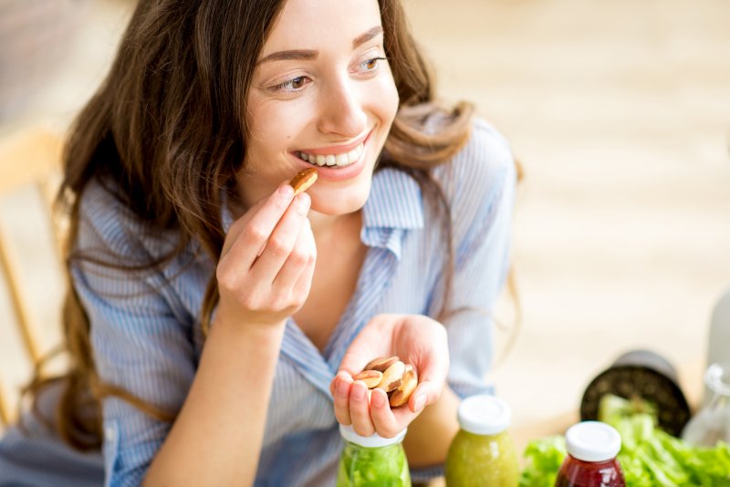 A woman eating nuts, one of the foods that can chip teeth