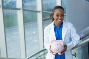 dentist in Dublin holding pink piggy bank 