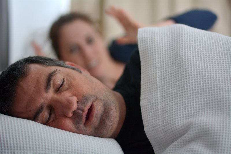 man with sleep apnea snoring in bed