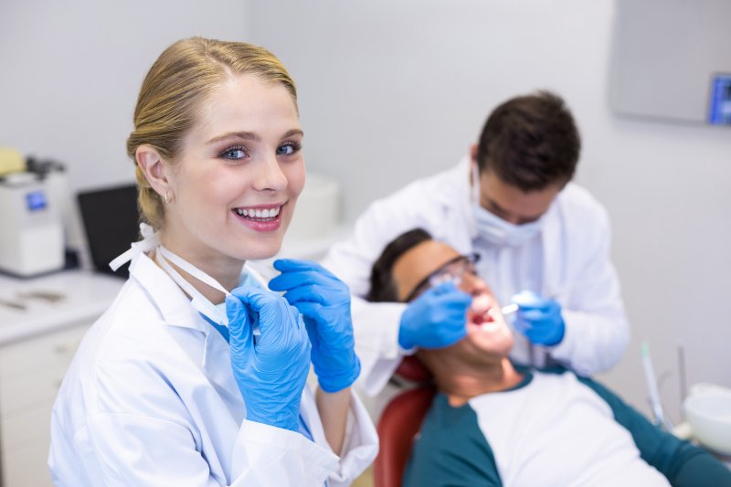 a dental hygienist smiling during a checkup and cleaning