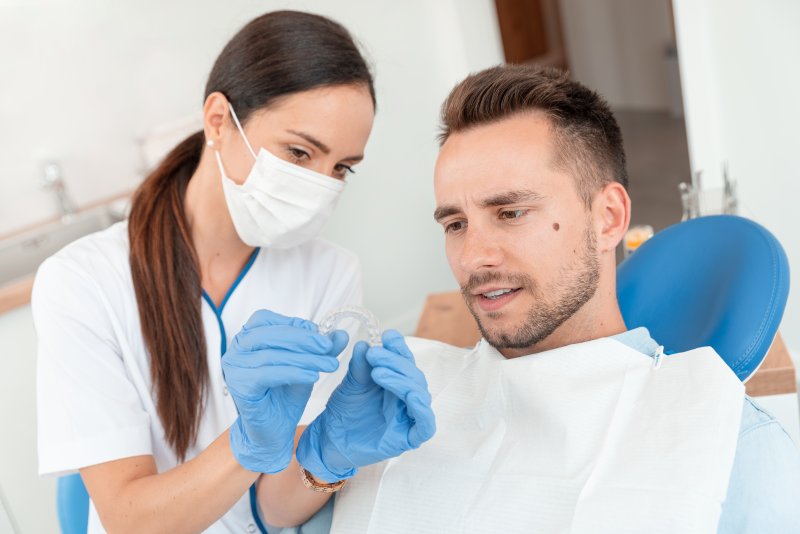 A dentist in Dublin showing a patient an Invisalign tray