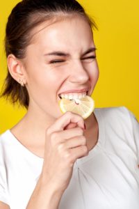 woman eating a lemon slice