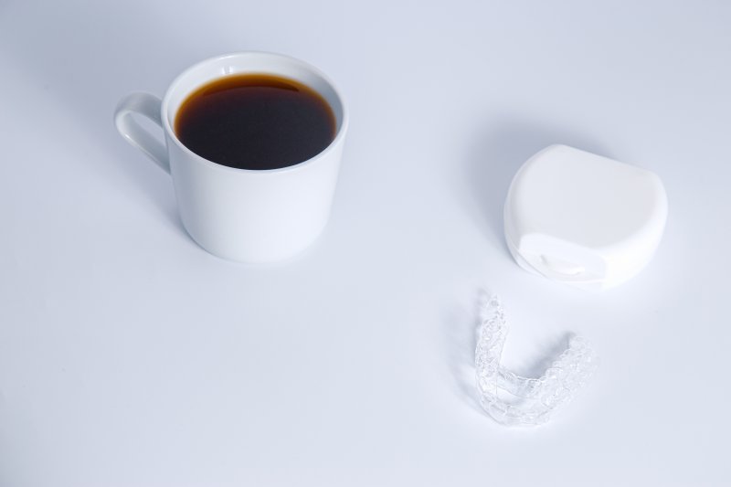 Isolated invisalign braces concept with a cup of coffee over white background