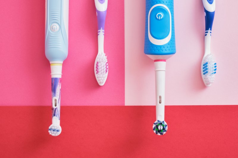 Manual and electric toothbrushes side by side