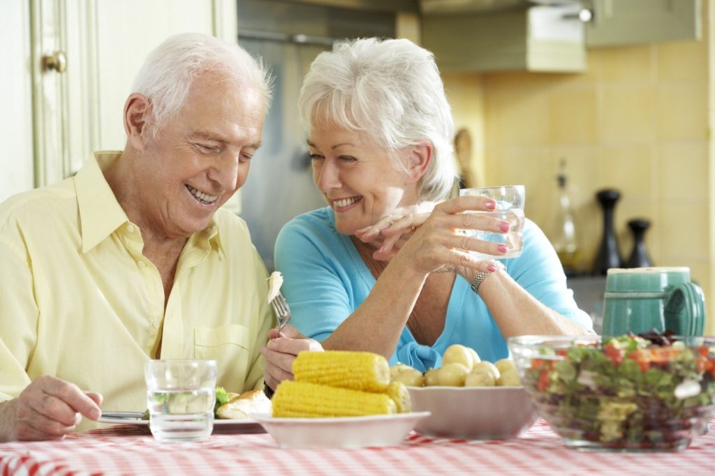 Elderly couple eating corn, one of the summer foods