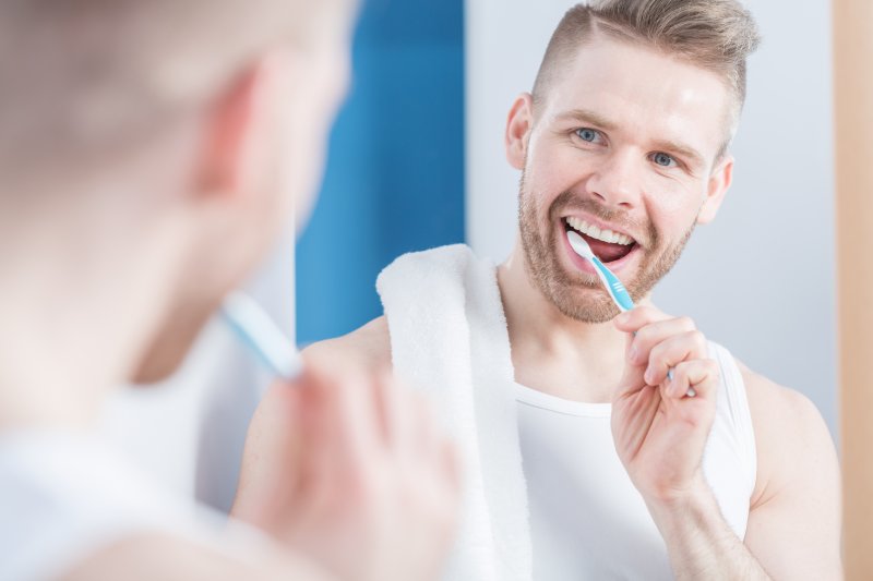 man smiling brushing as instructed by his dentist in Dublin